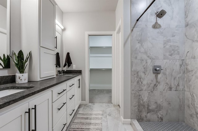 bathroom with tiled shower and vanity