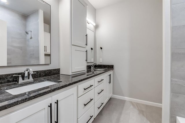 bathroom with vanity and a tile shower