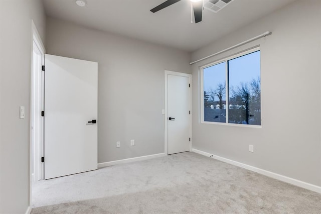 carpeted spare room with ceiling fan