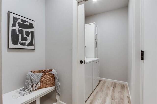 laundry area featuring washing machine and clothes dryer and light wood-type flooring