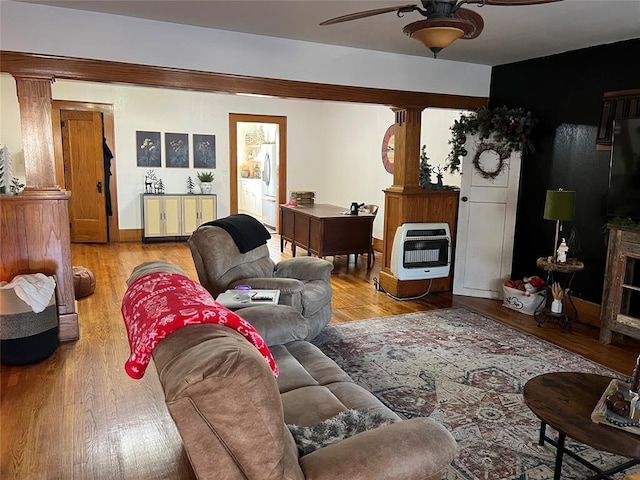 living room with heating unit, ceiling fan, and light hardwood / wood-style flooring