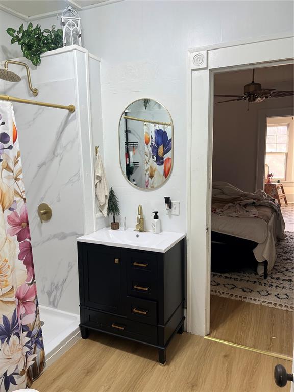 bathroom featuring a shower with curtain, vanity, crown molding, and wood-type flooring