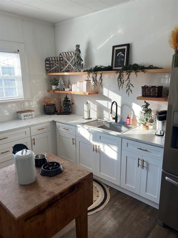 kitchen with dark hardwood / wood-style flooring, white cabinetry, sink, and tasteful backsplash