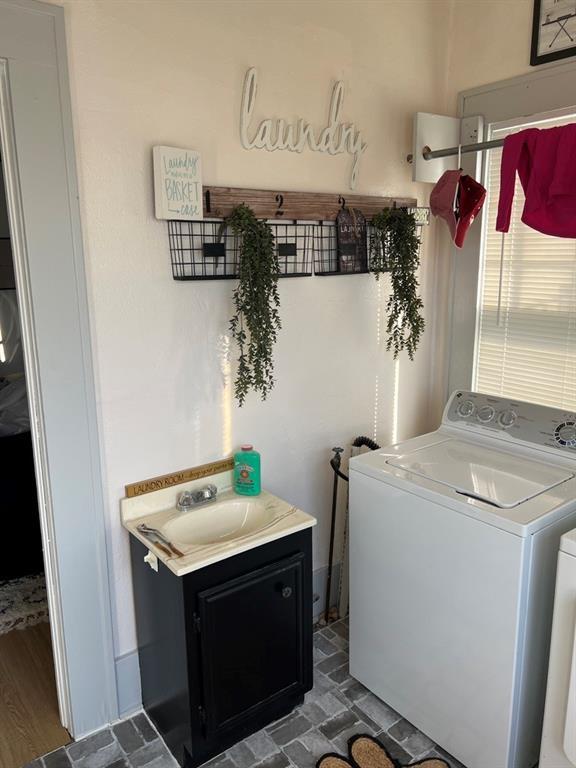 laundry area with dark hardwood / wood-style floors, sink, and washing machine and clothes dryer