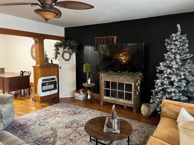 living room featuring a large fireplace, heating unit, and hardwood / wood-style floors