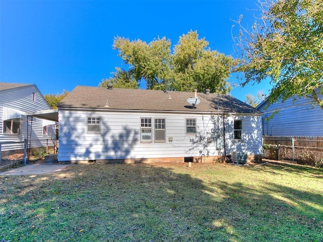 rear view of property with a yard and central air condition unit