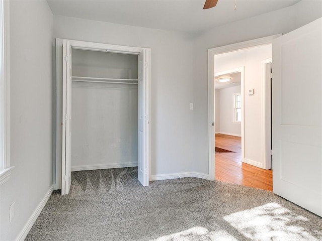 unfurnished bedroom with carpet, a closet, and ceiling fan