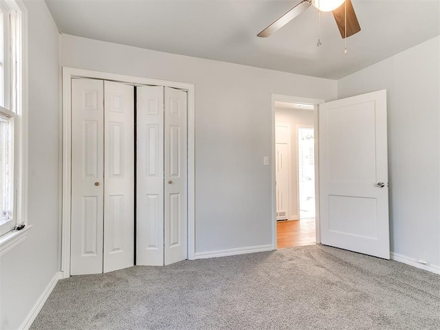 unfurnished bedroom featuring ceiling fan, light carpet, and a closet