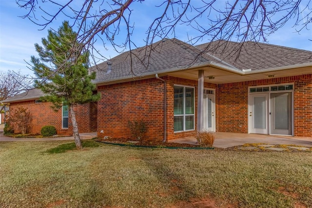 rear view of house featuring a yard and a patio