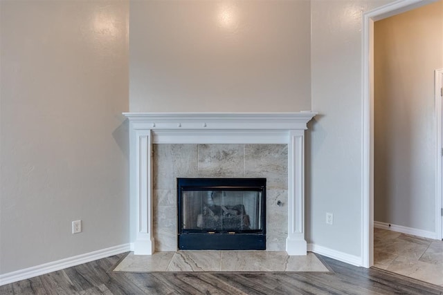 interior details with a tile fireplace and hardwood / wood-style floors