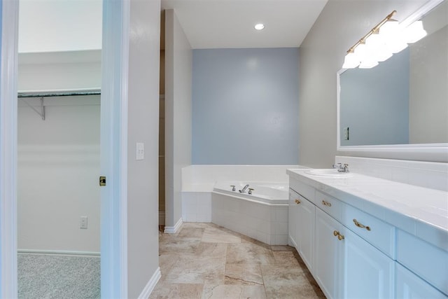 bathroom with tiled tub and vanity