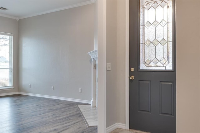 entrance foyer with ornamental molding, plenty of natural light, and wood-type flooring