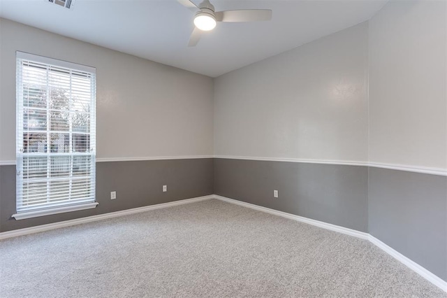 unfurnished room with ceiling fan and carpet