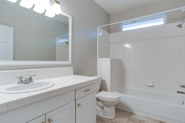 full bathroom featuring tile patterned floors, vanity, toilet, and tiled shower / bath combo