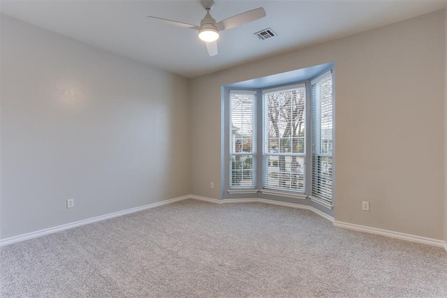 unfurnished room with light colored carpet and ceiling fan