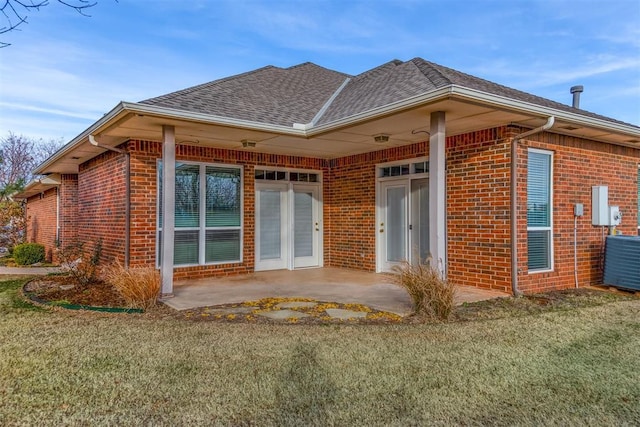 rear view of house featuring central air condition unit, a patio area, and a lawn