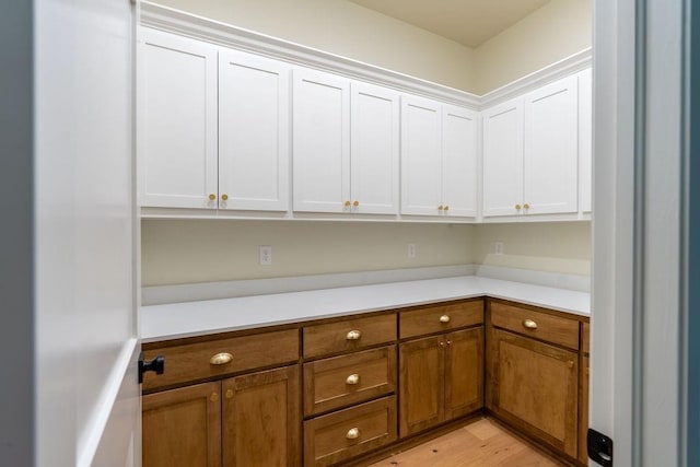 interior space with white cabinets and light hardwood / wood-style flooring