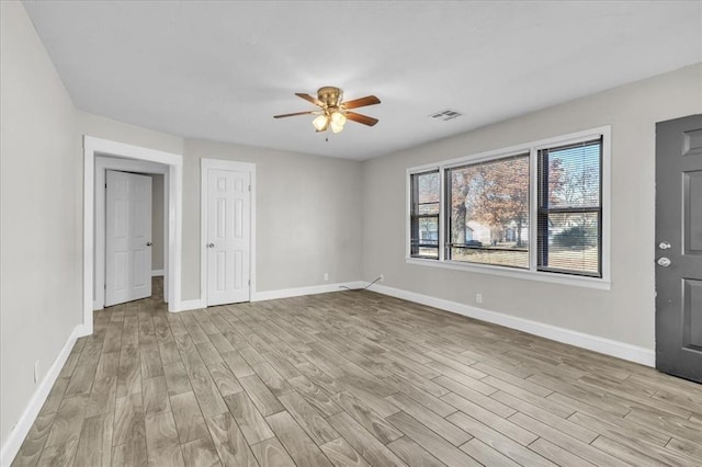 interior space featuring light wood-style floors, visible vents, ceiling fan, and baseboards