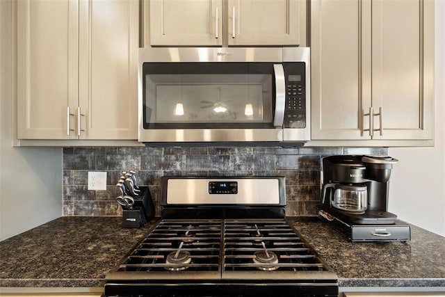 kitchen featuring stainless steel appliances, tasteful backsplash, and dark stone countertops