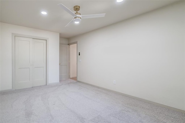 unfurnished bedroom featuring a closet, ceiling fan, and light colored carpet