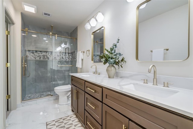 bathroom featuring vanity, a shower with shower door, and toilet