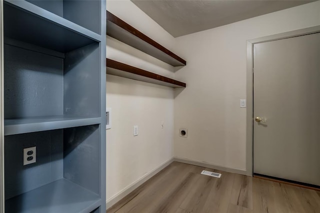 laundry area featuring electric dryer hookup and light hardwood / wood-style flooring