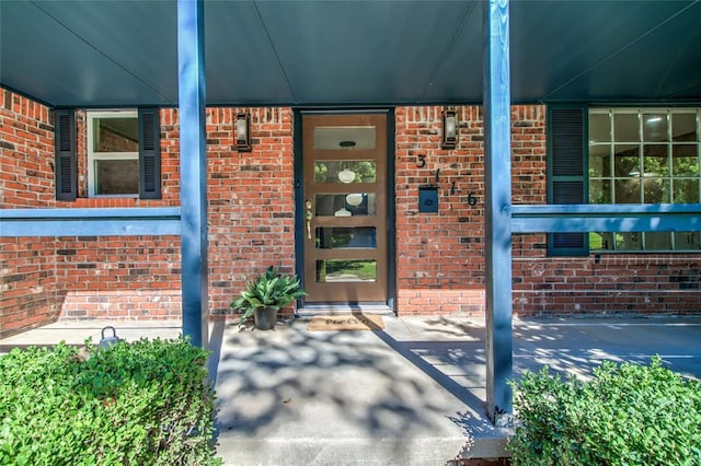 doorway to property featuring brick siding