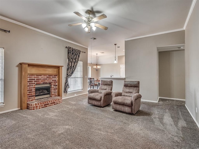 living room with a brick fireplace, carpet floors, ceiling fan with notable chandelier, and ornamental molding