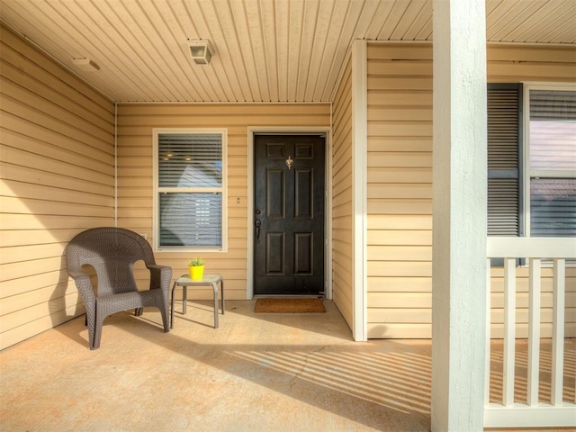 view of exterior entry featuring covered porch