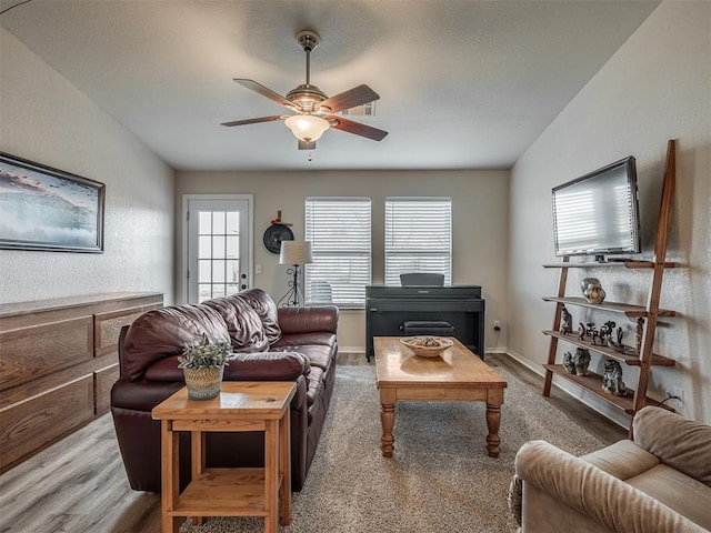 living room featuring vaulted ceiling, light hardwood / wood-style flooring, and ceiling fan