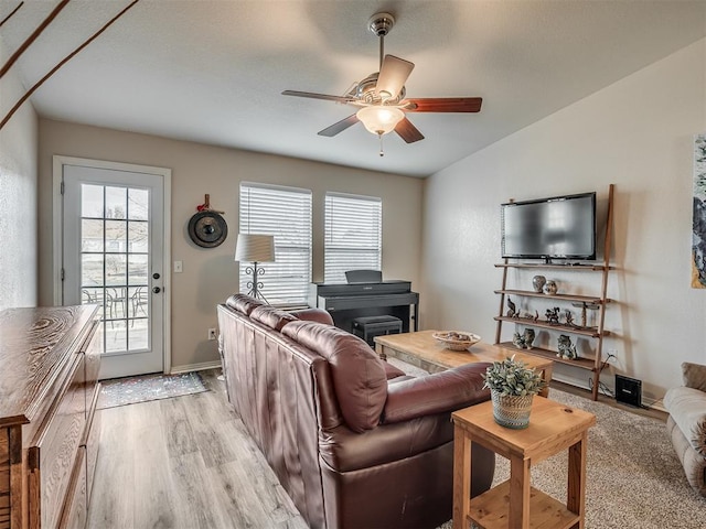 living room featuring ceiling fan, vaulted ceiling, and light wood-type flooring