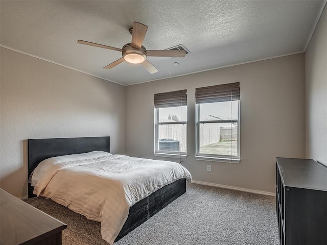 bedroom with ceiling fan, crown molding, carpet floors, and a textured ceiling