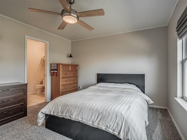 carpeted bedroom featuring ensuite bath, ceiling fan, and ornamental molding