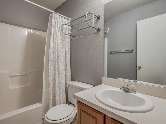 full bathroom featuring shower / bath combo, toilet, a textured ceiling, and vanity