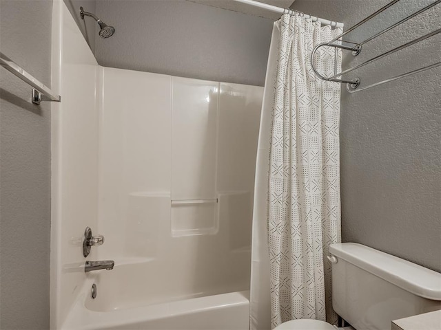 bathroom featuring shower / tub combo and toilet