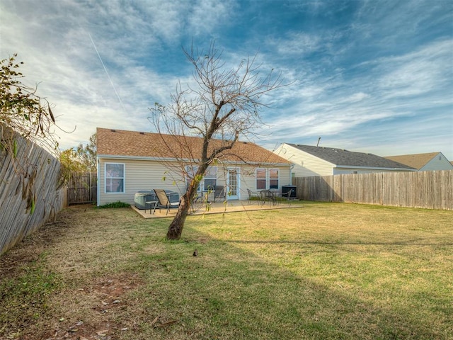 rear view of property with a lawn and a patio area