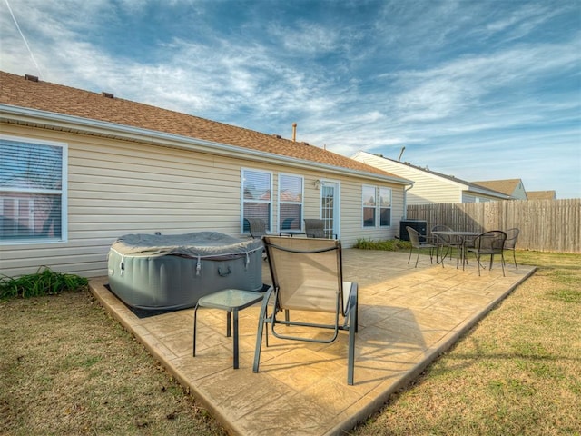 back of house with a patio and a lawn