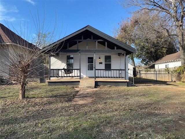 back of house with a porch and a yard