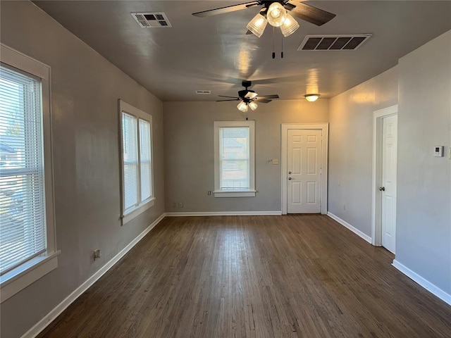 spare room with plenty of natural light, ceiling fan, and dark hardwood / wood-style flooring