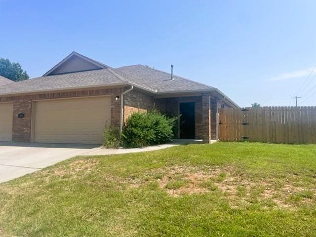 single story home with a garage and a front lawn