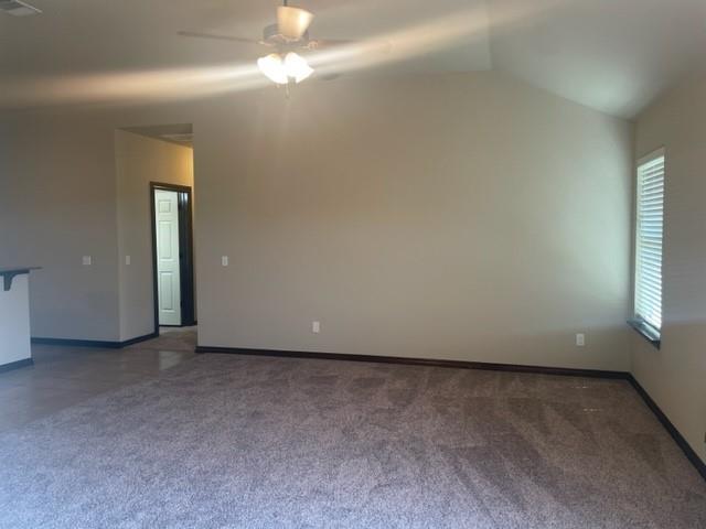 unfurnished room with plenty of natural light, lofted ceiling, and ceiling fan