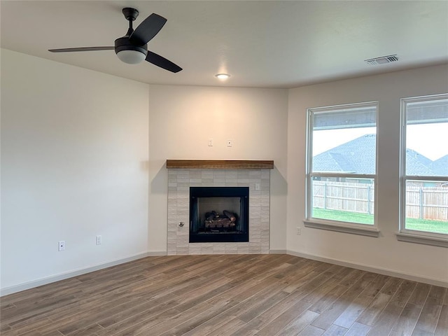 unfurnished living room featuring a fireplace, hardwood / wood-style floors, and ceiling fan