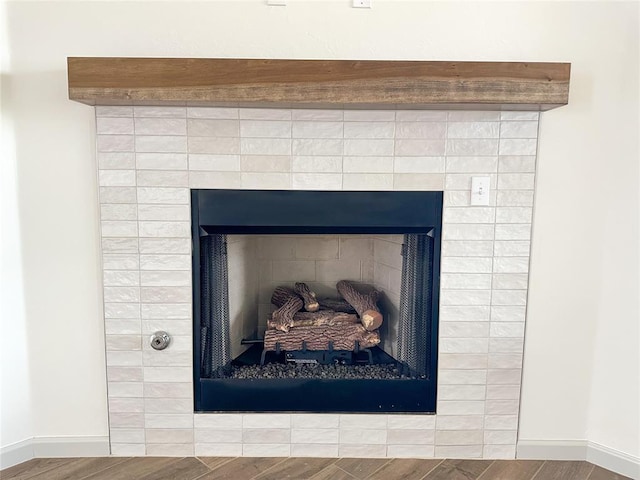 room details featuring wood-type flooring and a tile fireplace