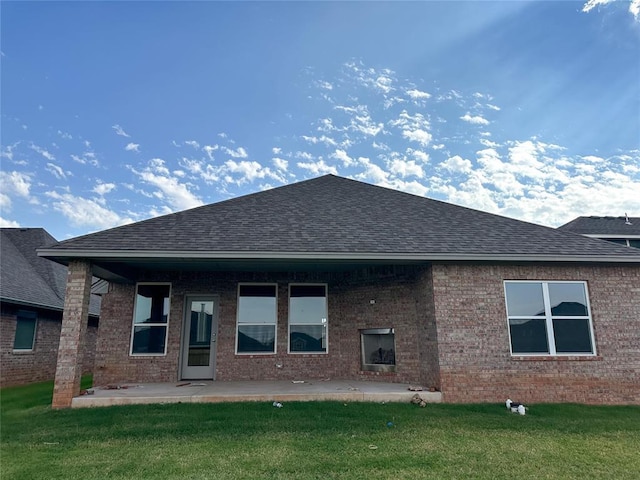 rear view of property with a patio and a lawn