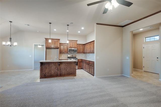 kitchen with a kitchen island with sink, hanging light fixtures, decorative backsplash, ornamental molding, and stainless steel appliances