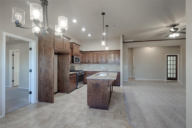 kitchen featuring sink, backsplash, an island with sink, light colored carpet, and appliances with stainless steel finishes