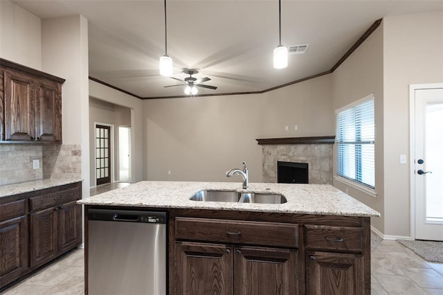 kitchen with dishwasher, a center island with sink, sink, light stone countertops, and dark brown cabinetry