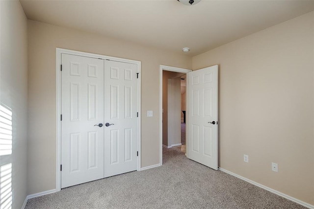 unfurnished bedroom with light carpet and a closet