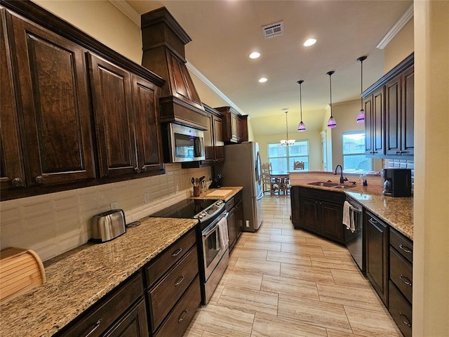 kitchen with sink, tasteful backsplash, dark brown cabinets, pendant lighting, and stainless steel appliances