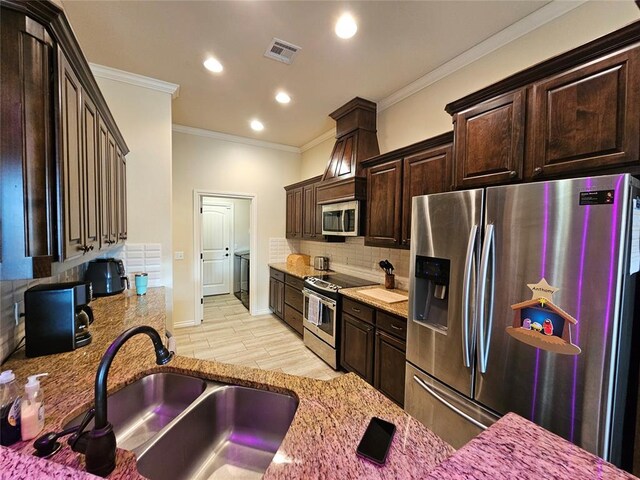 kitchen with sink, light hardwood / wood-style flooring, appliances with stainless steel finishes, backsplash, and light stone countertops